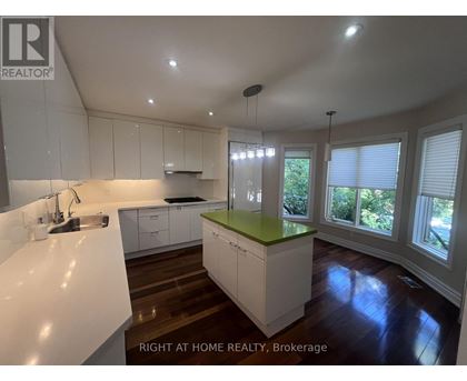 A kitchen with white cabinets and a green island.