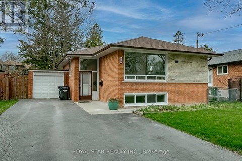 A house with a brown brick exterior and a white garage door is for sale.