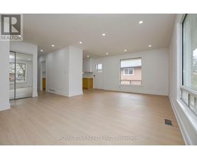 A spacious room with wooden flooring and white walls, part of a property brokerage by Royal Star Realty Inc.