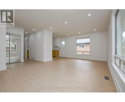 A spacious room with wooden flooring and white walls, part of a property brokerage by Royal Star Realty Inc.