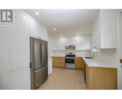 A modern kitchen with wooden cabinets and stainless steel appliances.