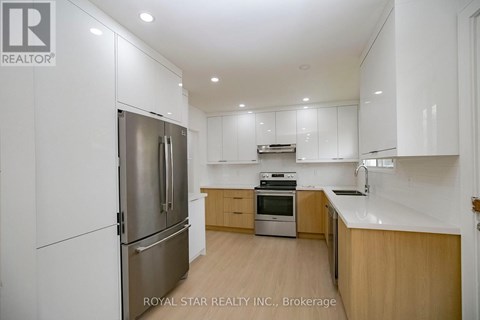 A modern kitchen with wooden cabinets and stainless steel appliances.