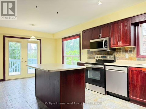 A kitchen with wooden cabinets and a black counter.