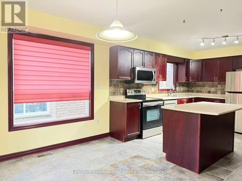 A kitchen with a red countertop and a stove top oven.