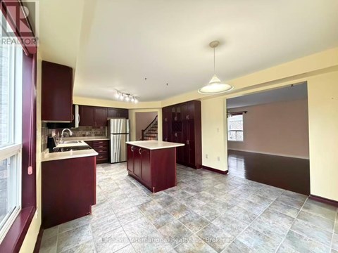 A kitchen with a maroon and beige color scheme.