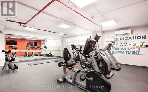 A gym with a variety of equipment and motivational words on the wall.