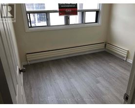 A room with a grey floor and a window with a sign that says "Sale".