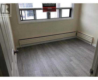 A room with a grey floor and a window with a sign that says "Sale".