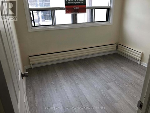 A room with a grey floor and a window with a sign that says "Sale".