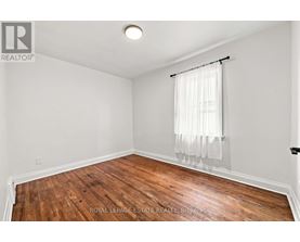 A room with wooden flooring and white walls.