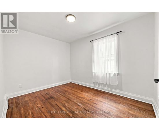 A room with wooden flooring and white walls.