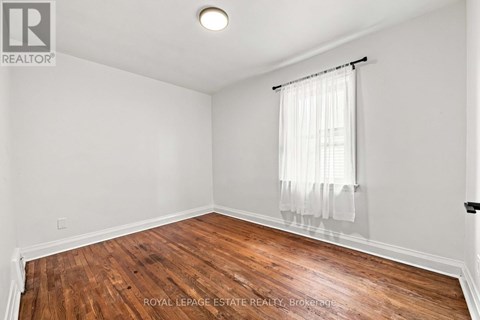 A room with wooden flooring and white walls.