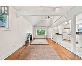 A spacious room with wooden floors and white walls.