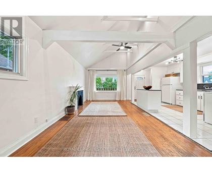 A spacious room with wooden floors and white walls.