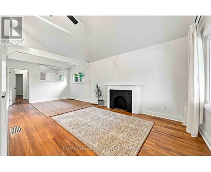 A living room with a fireplace and a rug on the floor.
