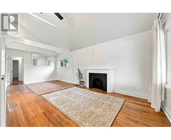 A living room with a fireplace and a rug on the floor.