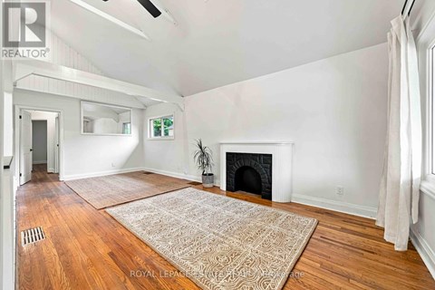 A living room with a fireplace and a rug on the floor.