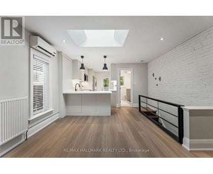 A spacious room with a skylight and a balcony with a railing.