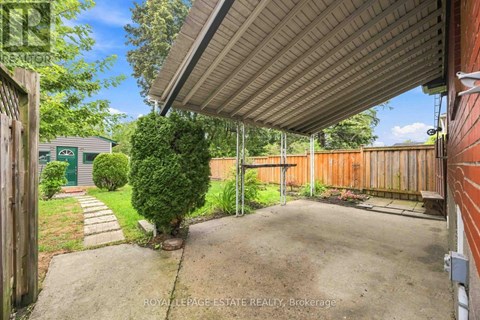 A backyard with a concrete pathway and a wooden fence.