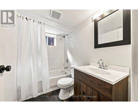 A white bathroom with a toilet, sink, and shower.