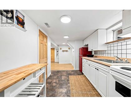 A kitchen with white cabinets and a red fridge.