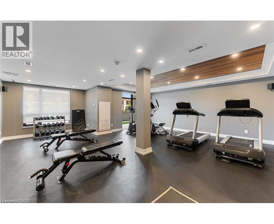 A gym with treadmills and weights is labeled REALTOR.