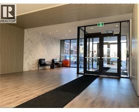 A modern office lobby with a black and white rug, a wooden floor, and a glass door leading outside.