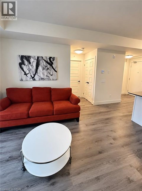 A kitchen with a refrigerator, microwave, and a dining table with chairs.