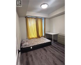 A bedroom with a bed, desk, and chair.