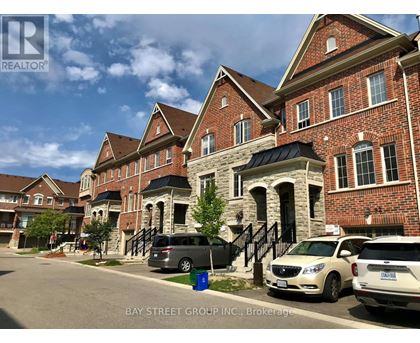 A row of houses with cars parked in front.