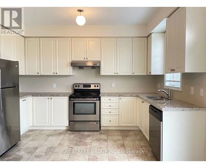 A kitchen with white cabinets and a tile floor.