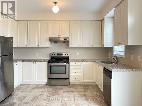 A kitchen with white cabinets and a tile floor.