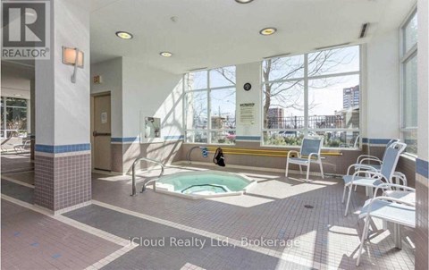 A pool area with a person sitting on a chair.