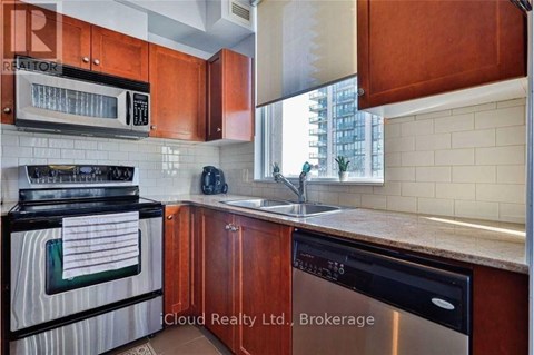 A kitchen with wooden cabinets and a black stove top oven.