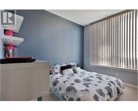 A bedroom with a bed, nightstand, and a window with blinds.
