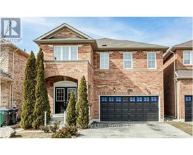 A brick house with a black garage door and a large front door.