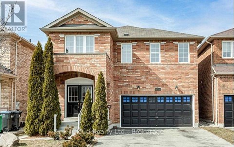 A brick house with a black garage door and a large front door.