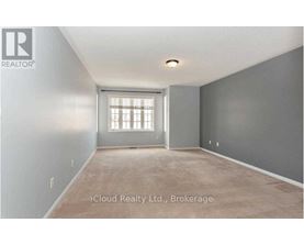 A room with a window and a carpeted floor.
