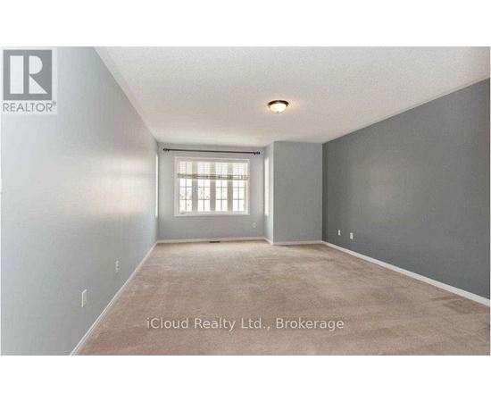 A room with a window and a carpeted floor.