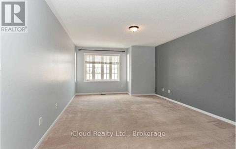 A room with a window and a carpeted floor.