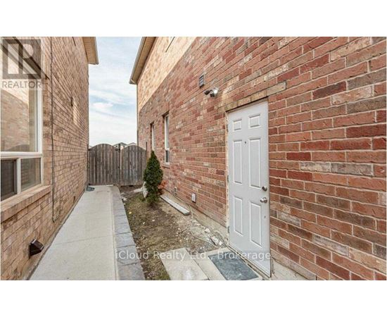 A small white door is on the side of a brick building.