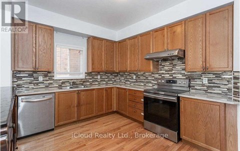 A kitchen with wooden cabinets and a stone backsplash.