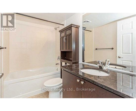 A bathroom with a white toilet, a sink, and a bathtub.