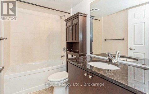 A bathroom with a white toilet, a sink, and a bathtub.