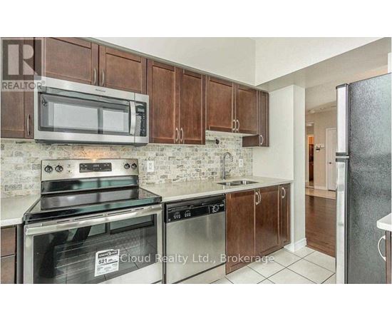 A kitchen with brown cabinets and stainless steel appliances.