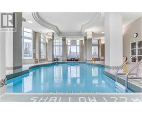 A large indoor swimming pool with a tiled edge and a white floor.