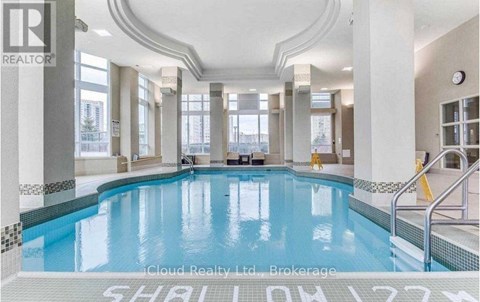 A large indoor swimming pool with a tiled edge and a white floor.