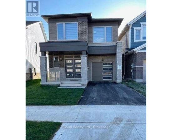 A modern house with a grey front yard and a driveway.