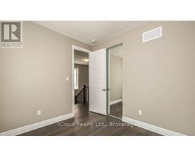 A room with a white door and a brokerage sign on the wall.