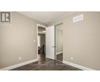 A room with a white door and a brokerage sign on the wall.